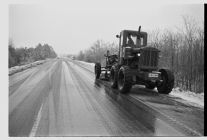 Snow plow clears highway.